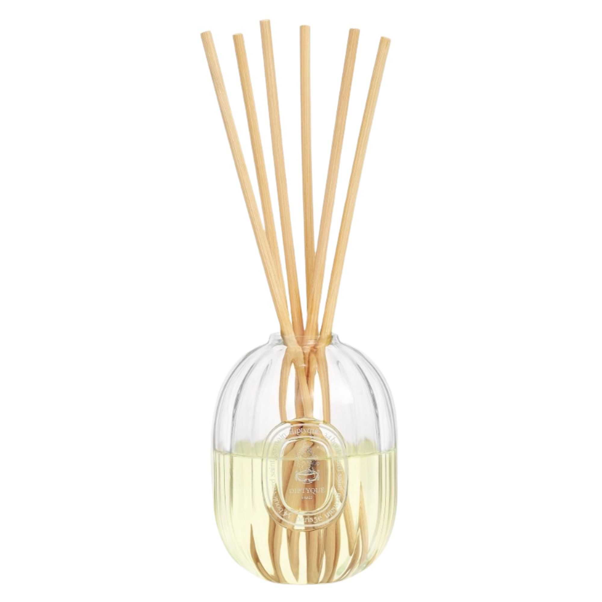 Diptyque Ambre diffuser with a fluted glass vessel and wooden reeds