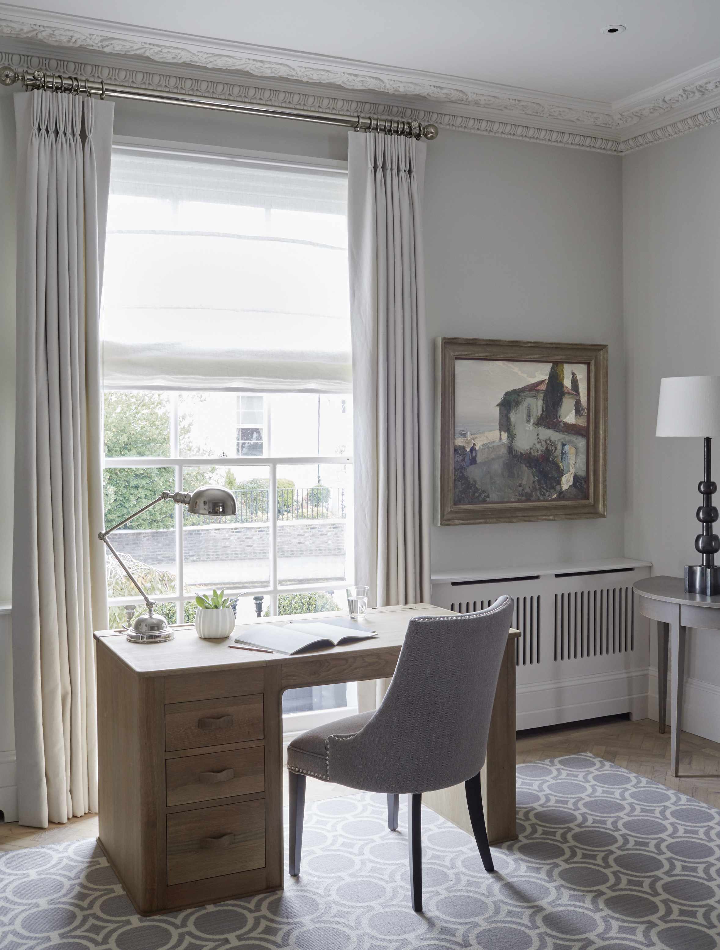 Wooden desk facing window, bright wall, floor and carpet