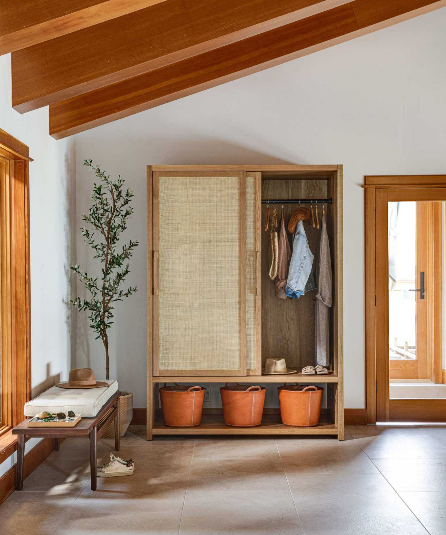mud room with screened closet and storage buckets