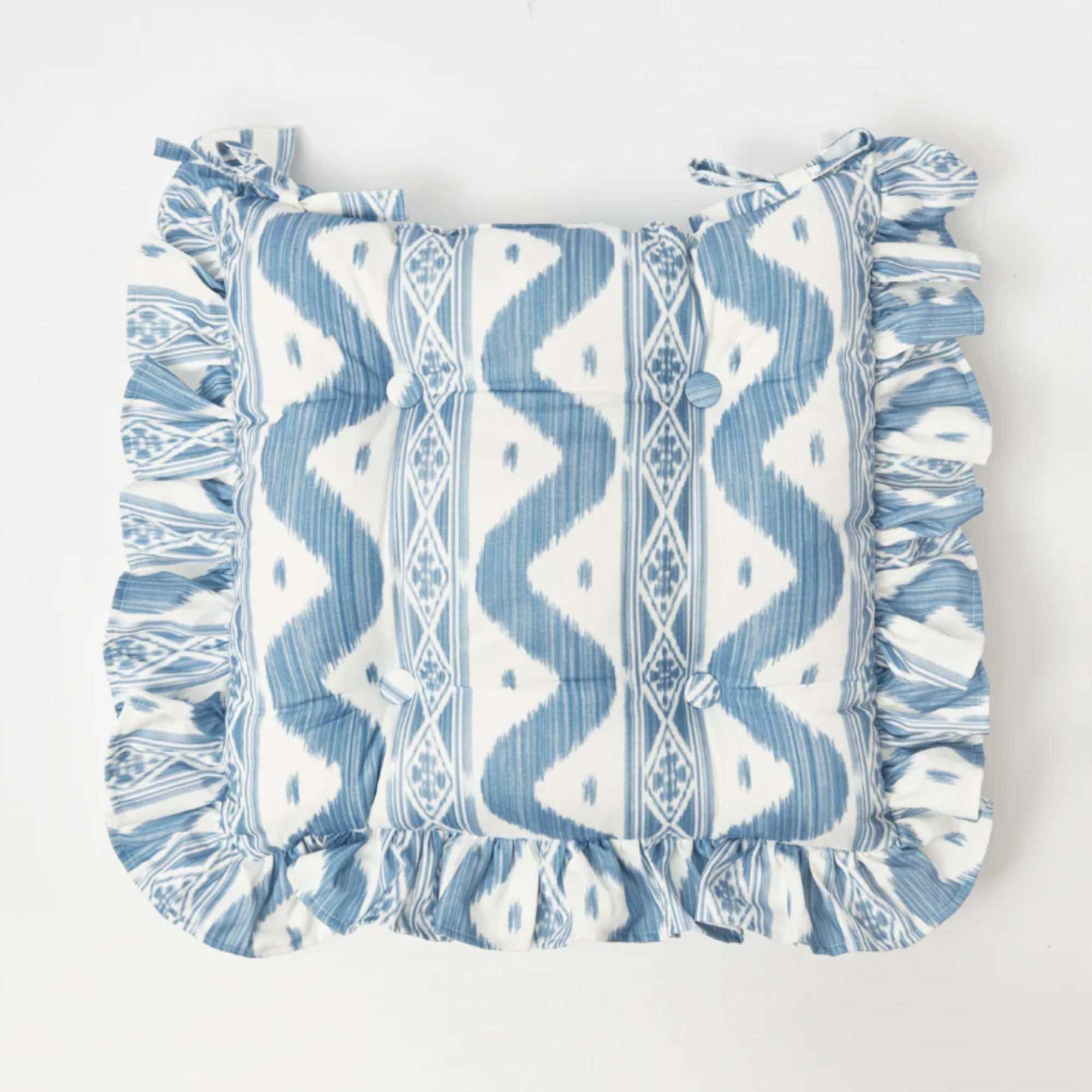 Blue and white ikat print seat cushion with frilled edges