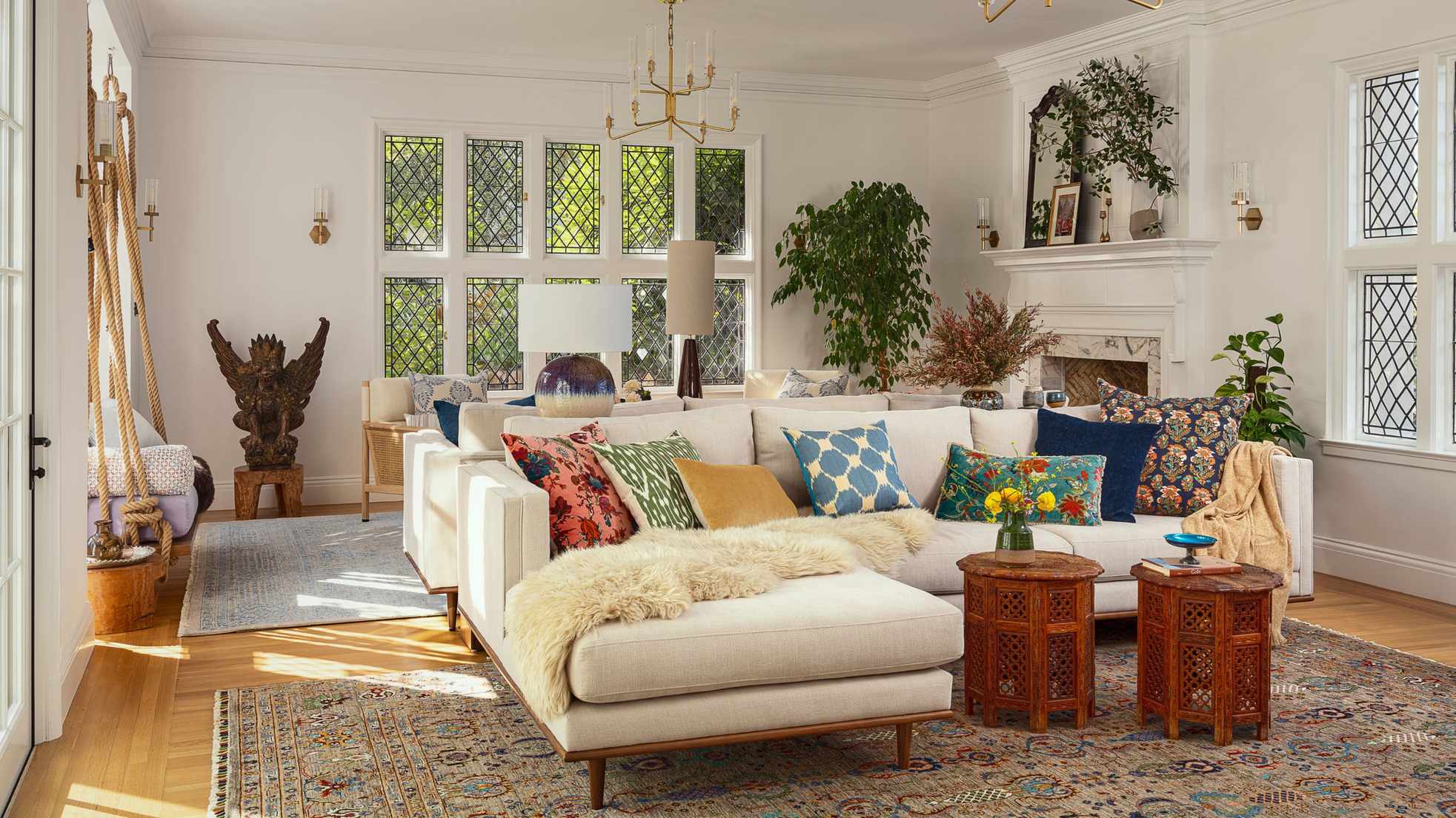 a white painted living room in a tudor home with original windows and fireplaces