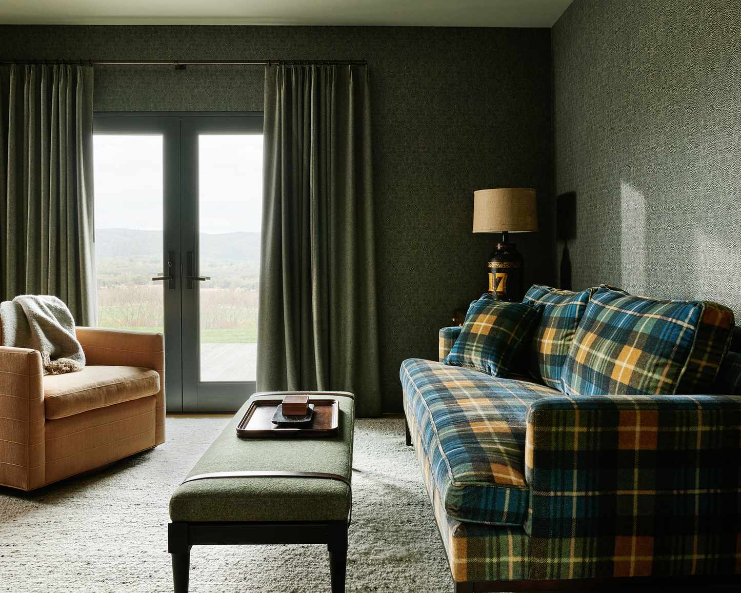 calm living room with plaid sofa and brown armchair