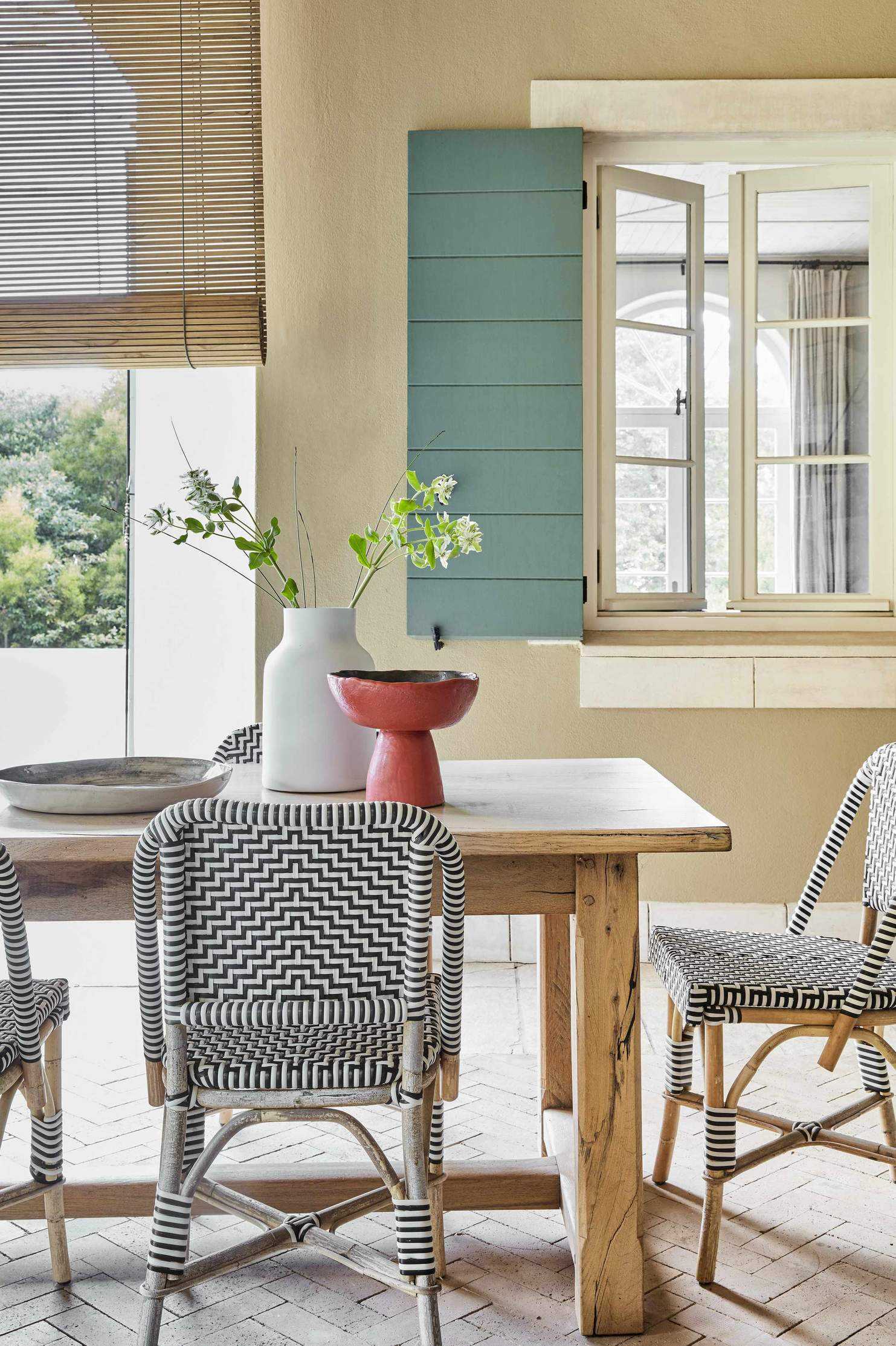 A wooden table with bistro chairs on a brick floor