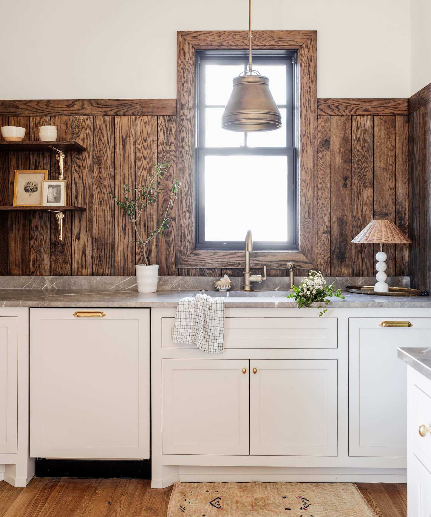 neutral kitchen with wood clad upper wall, white cabinets, rustic decor