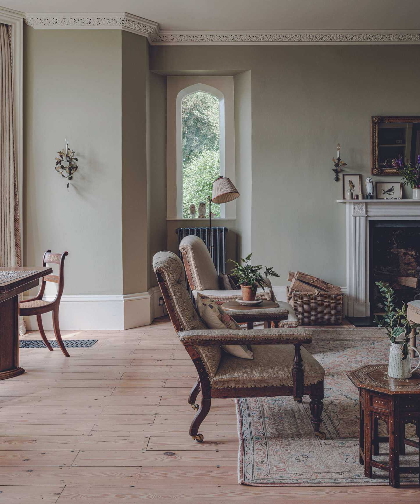 living space with light green walls and antique wooden chairs and wooden floors and sidetable and rug