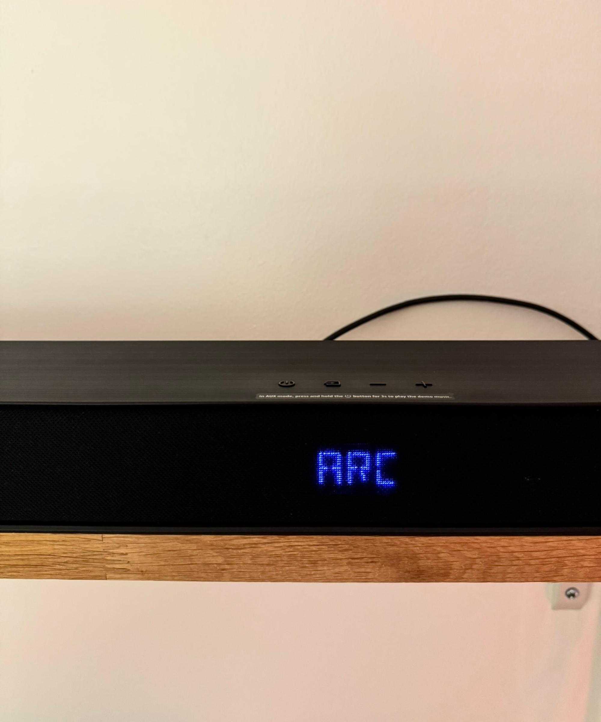 Hisense AX5140Q soundbar on wooden shelf, with blue lit-up text displaying 'ARC'.