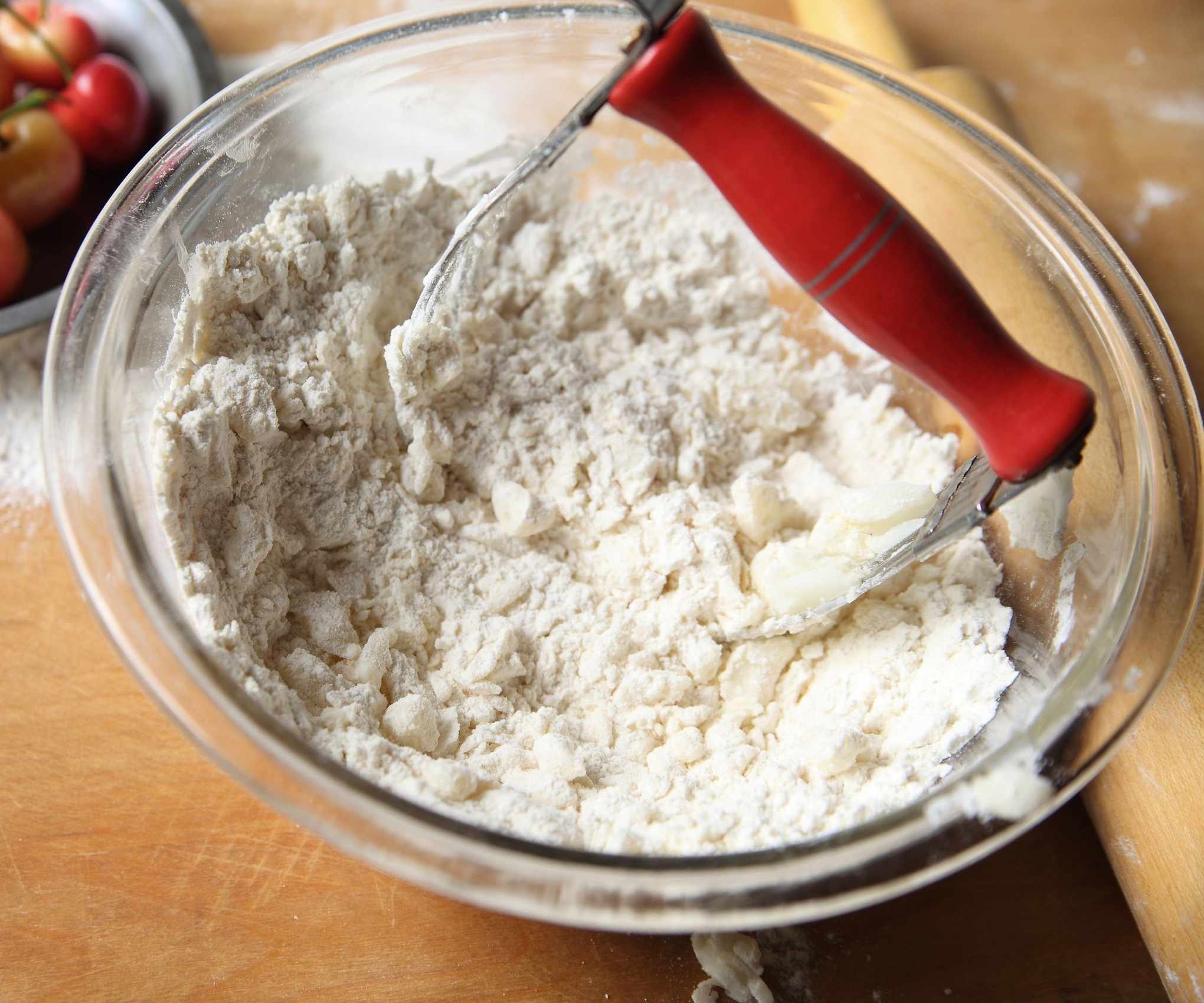 A mixing bowl with a pastry blender making pastry
