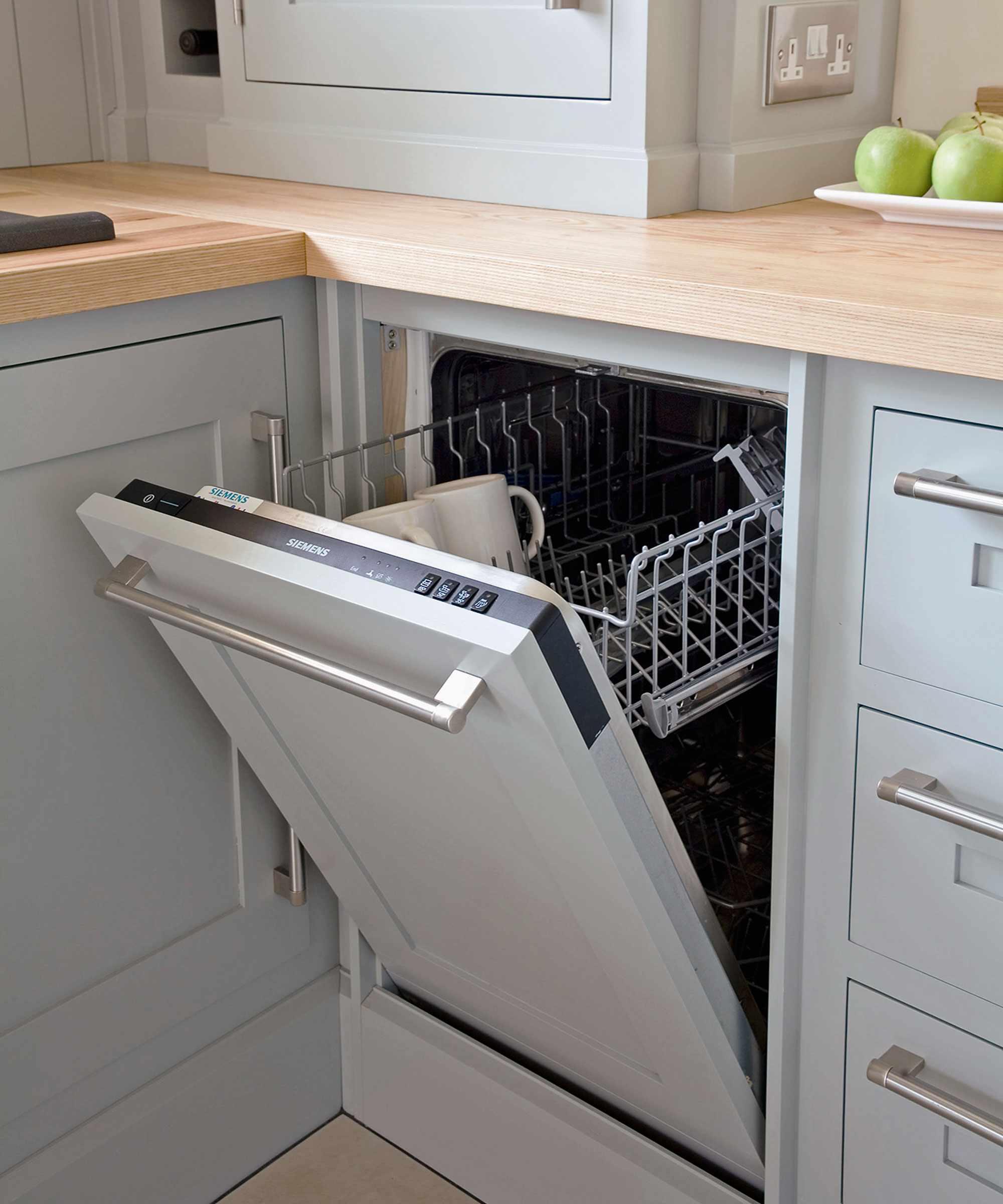 blue kitchen cabinets with open dishwasher door