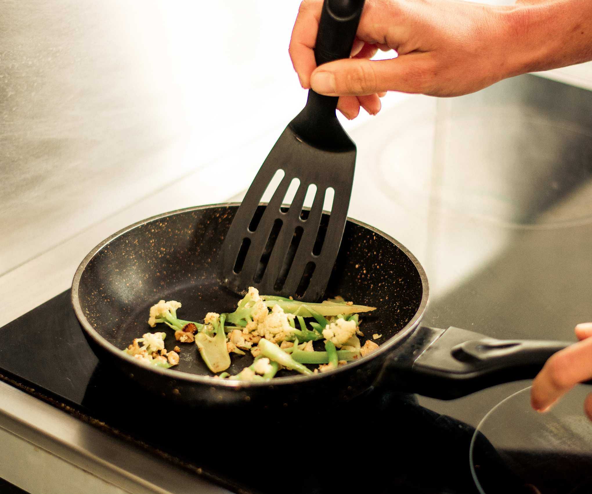 A black plastic spatula in a frying pan