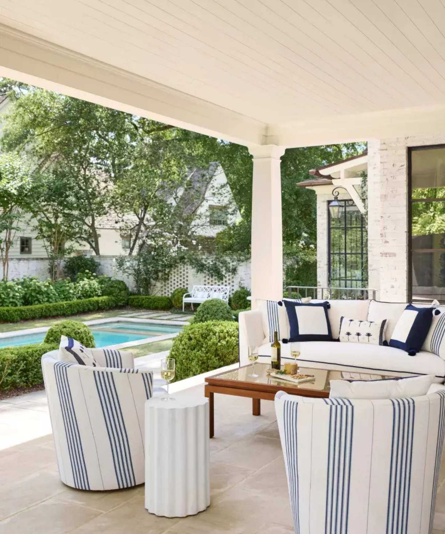 hamptons outdoor patio outdoor living room next to a pool with blue and white coastal furniture