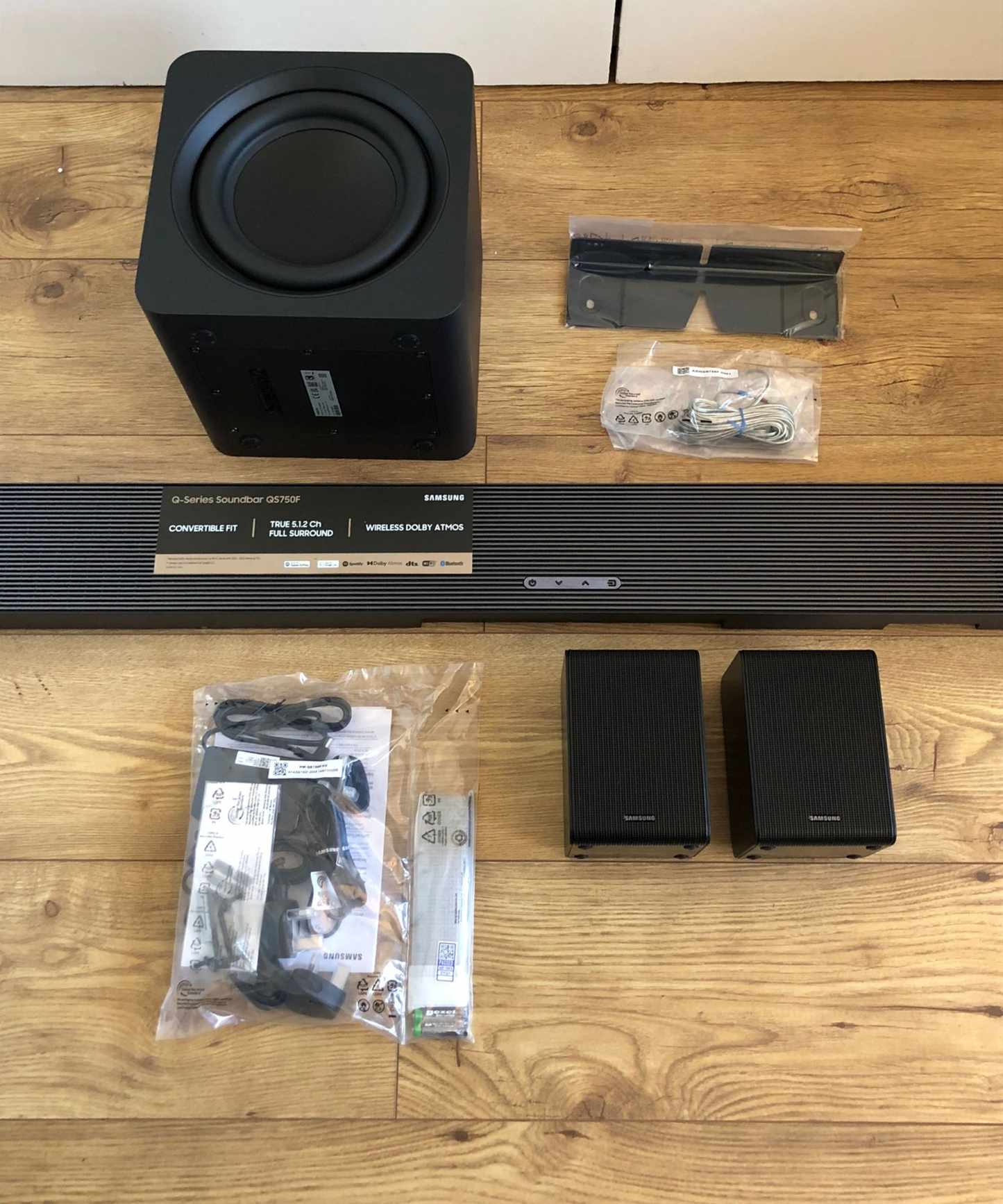 All components of the Samsung HW-QS750F soundbar on wooden floor in Dan Fauzi's home.