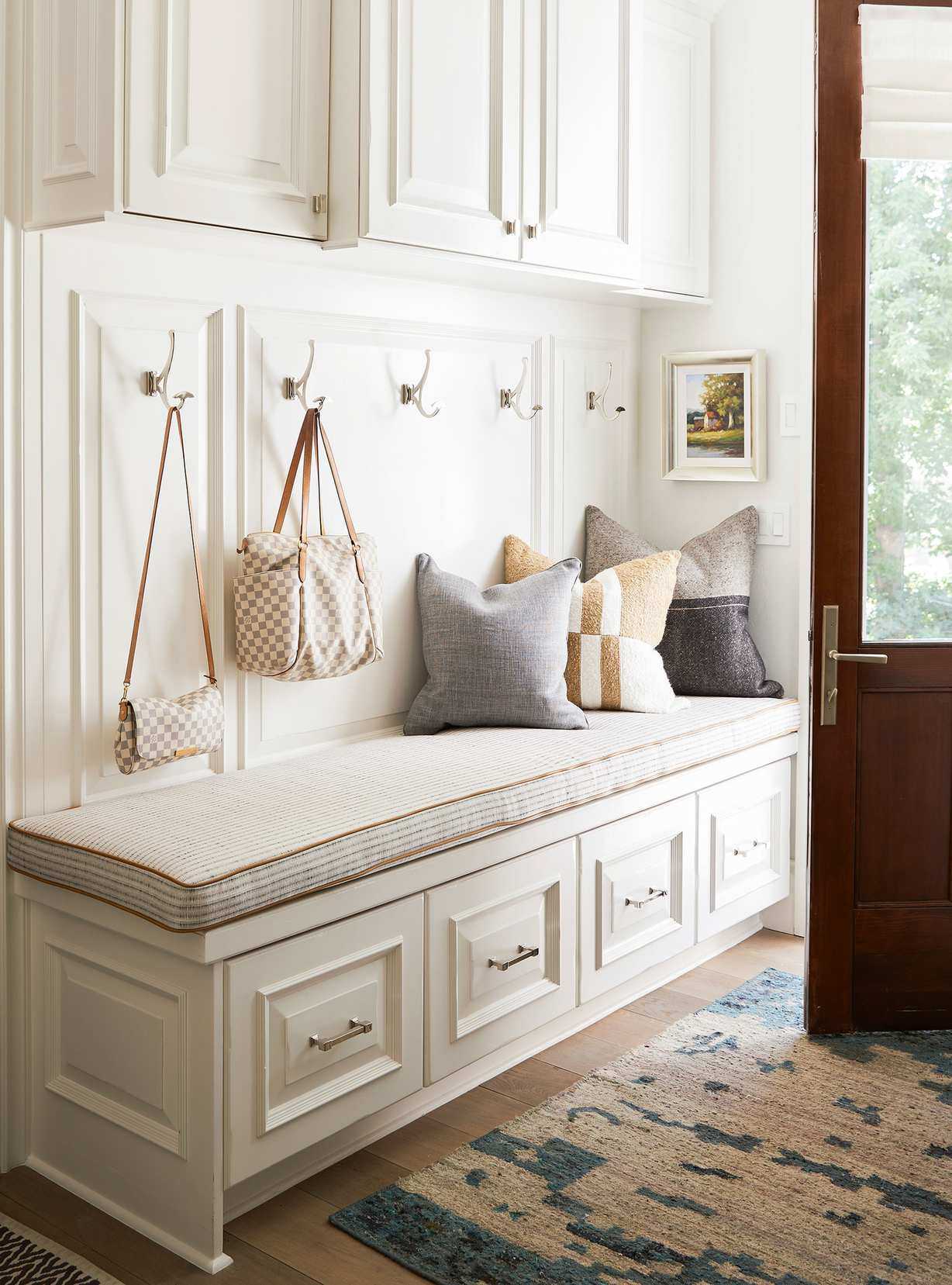 Small white entryway with bespoke storage and wood floor