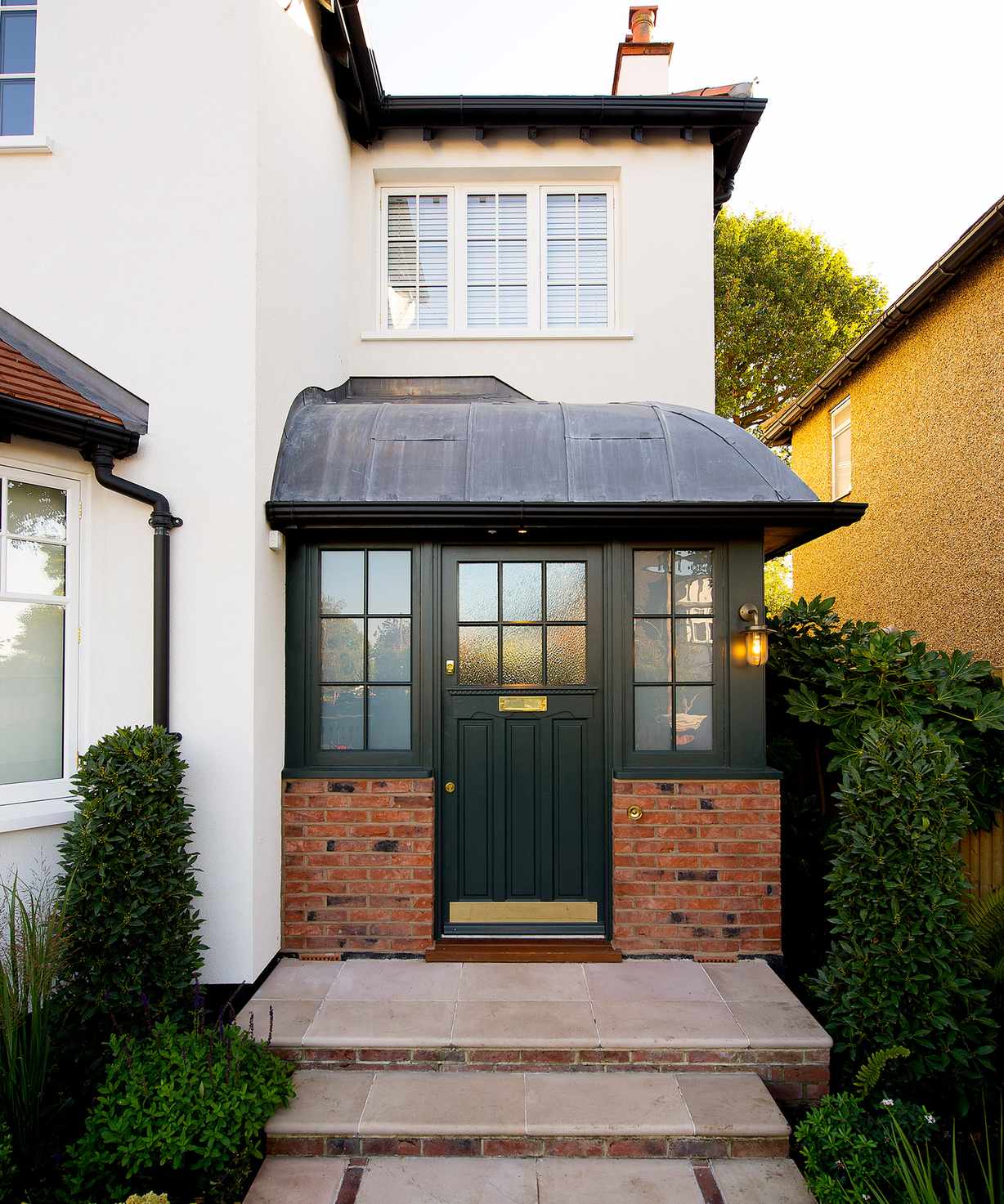 A small brick front porch on a white house