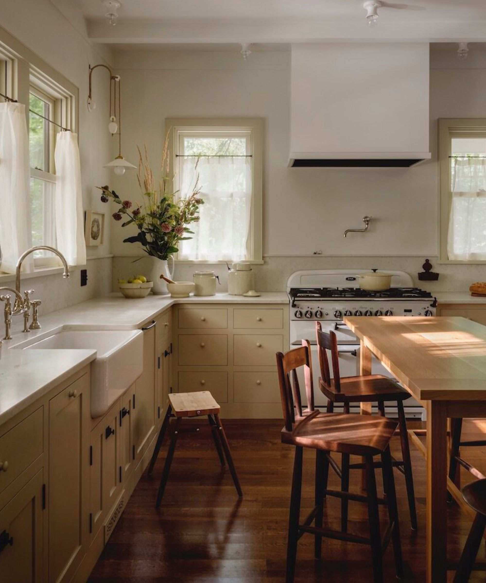 neutral shaker kitchen with vintage furniture and cafe curtains at the window