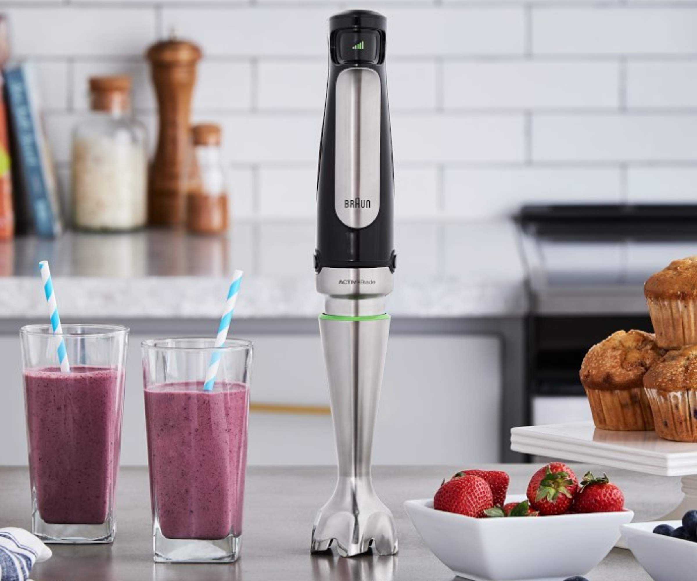 Braun immersion hand blender on a countertop next to smoothies and muffins