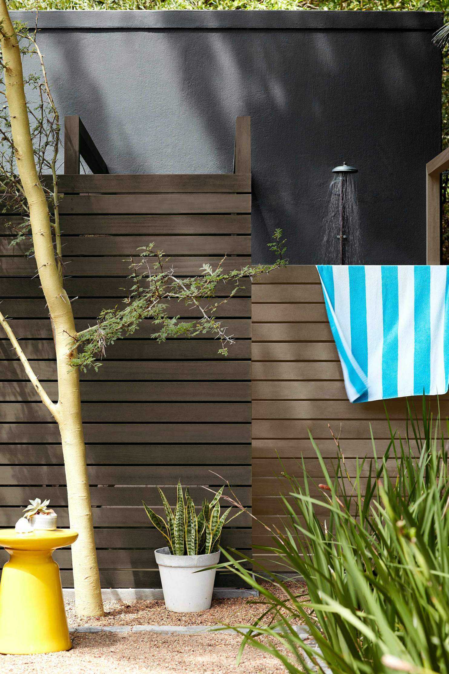 Fence painted dark brown with shower behind