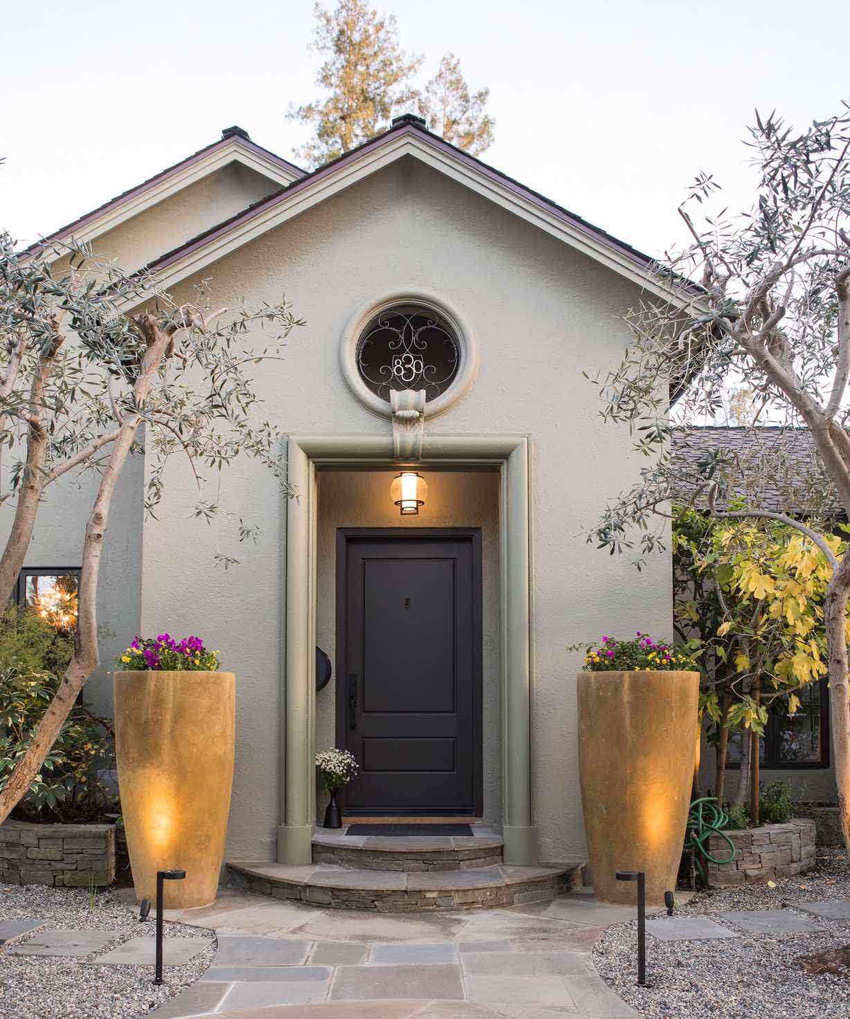 Front door with brown door and lighting