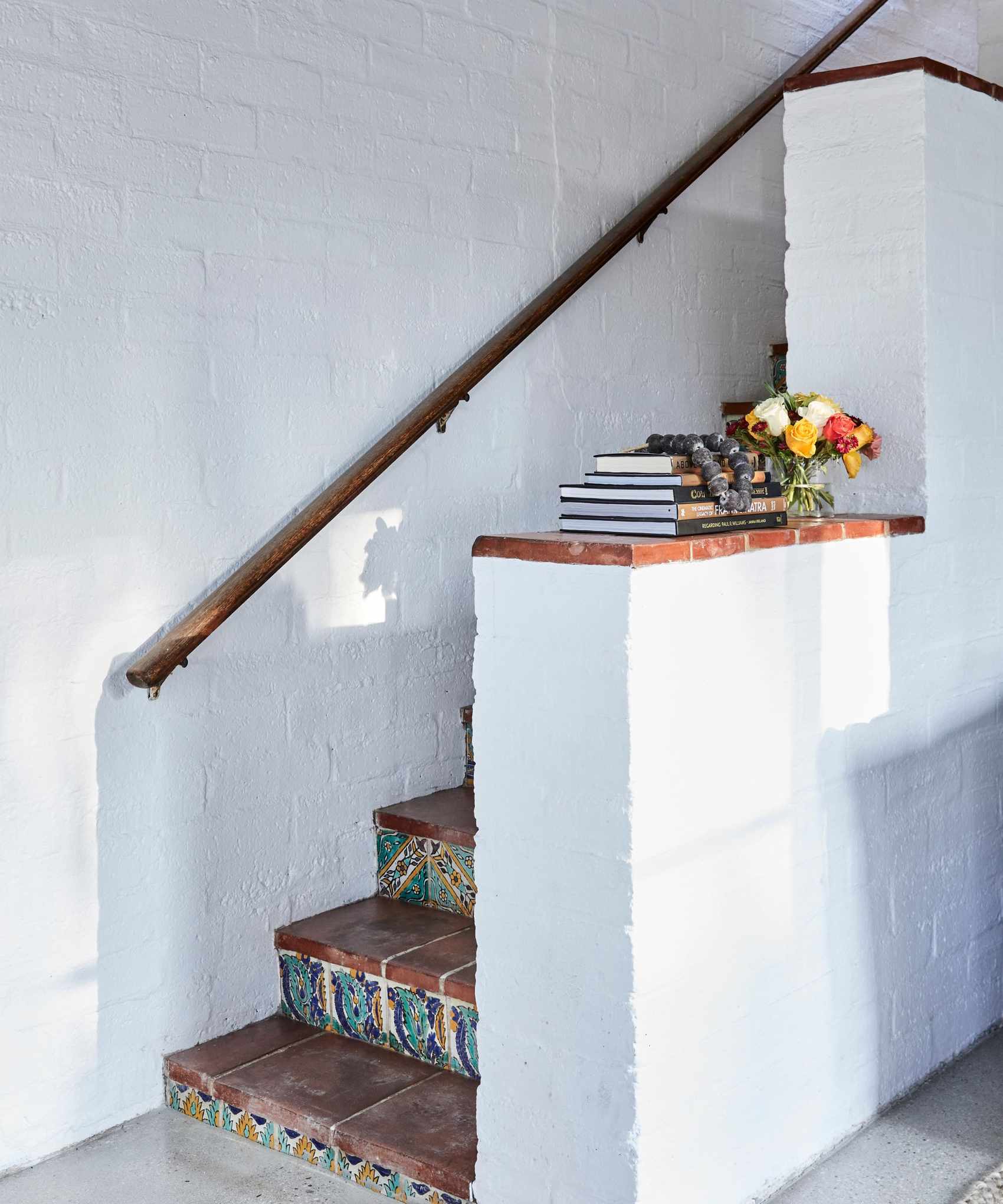 stairs with patterned tiles in Mediterranean style home with whitewashed walls