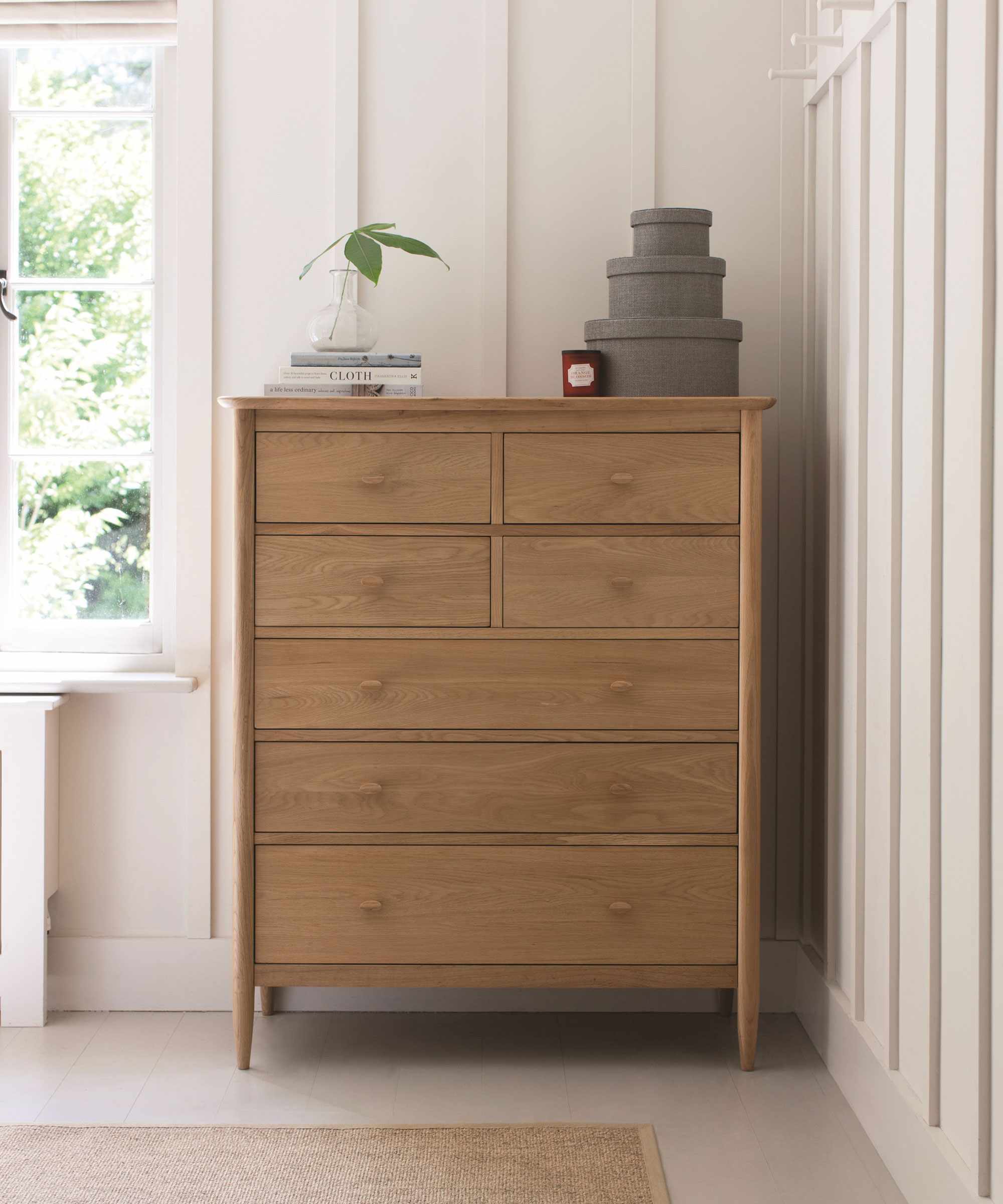 Neutral bedroom with tall wooden chest of drawers
