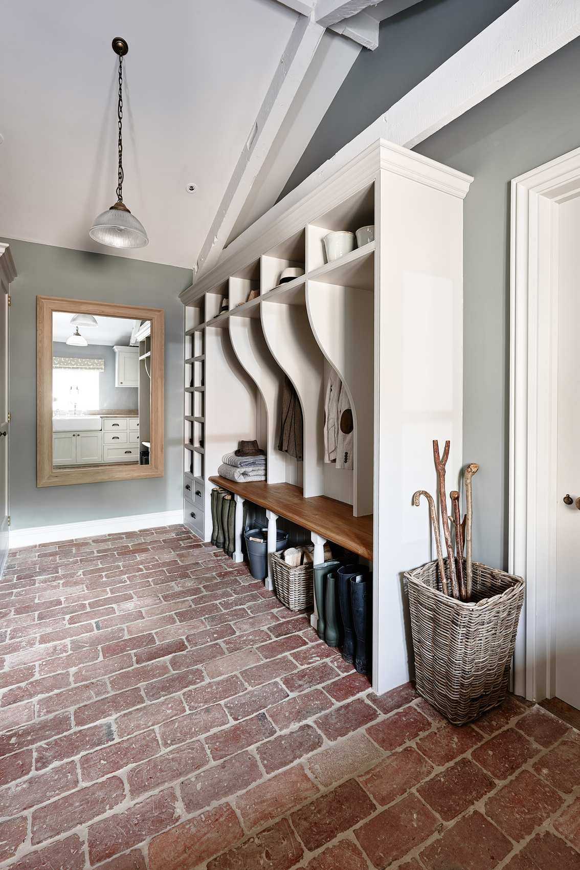 A traditional mudroom with original flooring, wicker basket storage and a long wall mirror