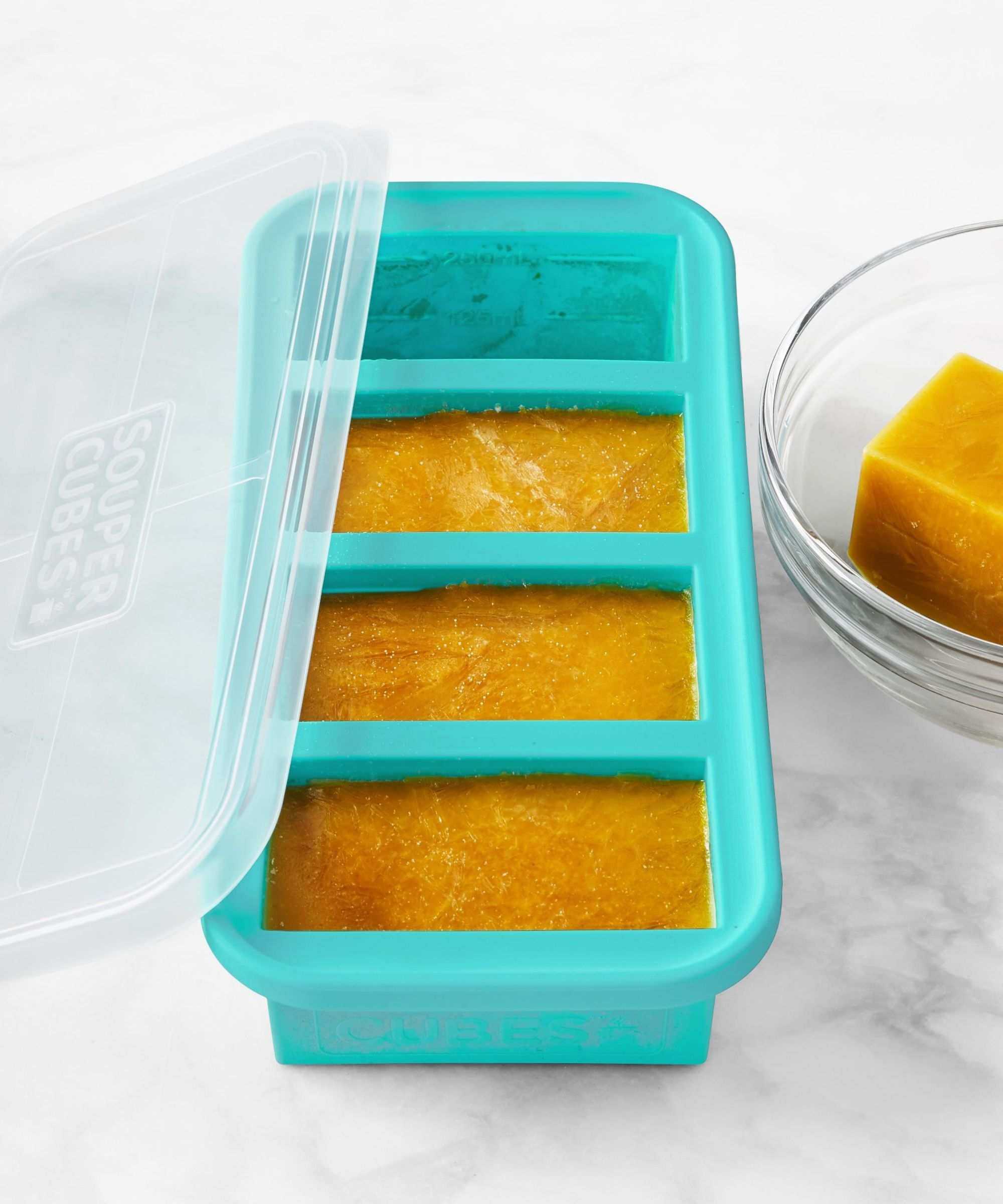 Souper Cubes showing frozen orange liquid that looks to be butternut squash soup