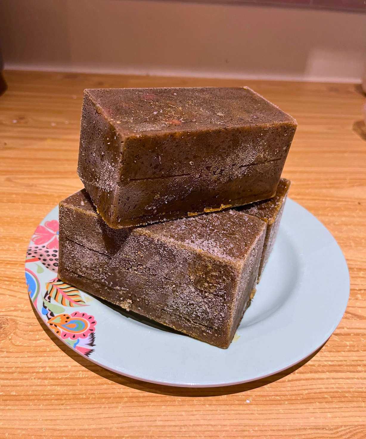 Multiple stacked blocks of deep green frozen Persian herby lamb stew (ghormeh sabzi) on a side plate