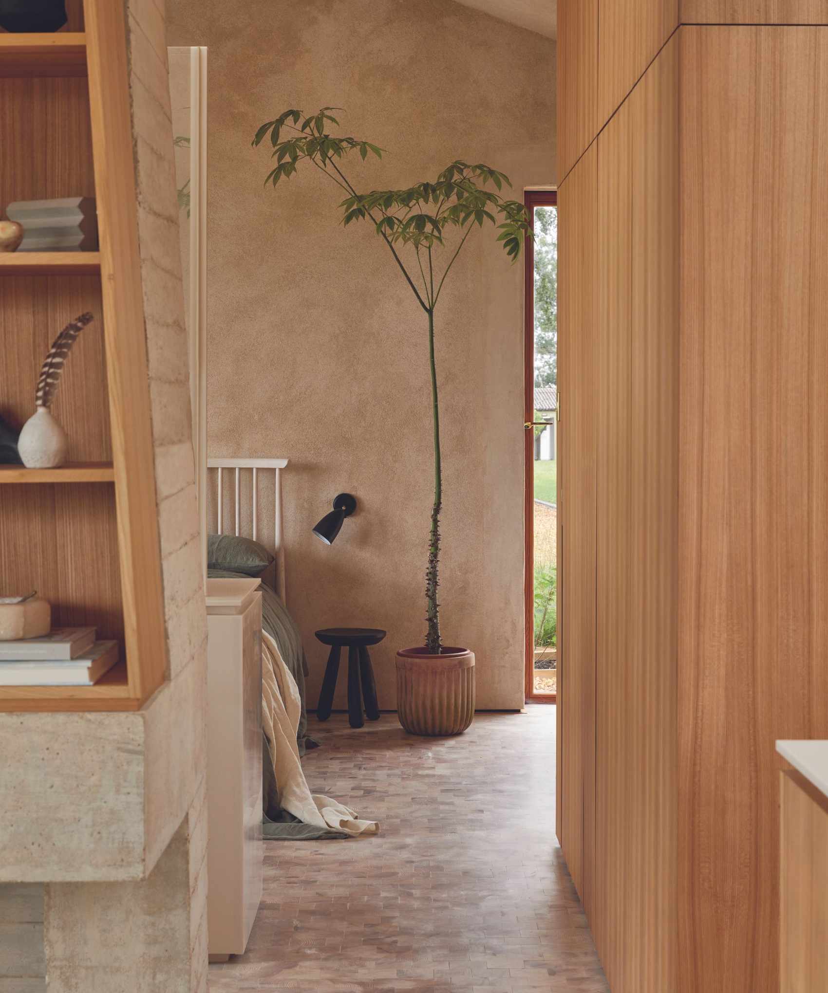 bedroom with pale earth colours and stone floor and wooden walls