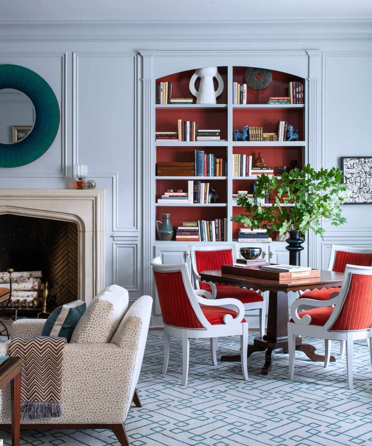 living room design by L.B.Copeland with cool blue walls and hot red-orange shelves and chairs