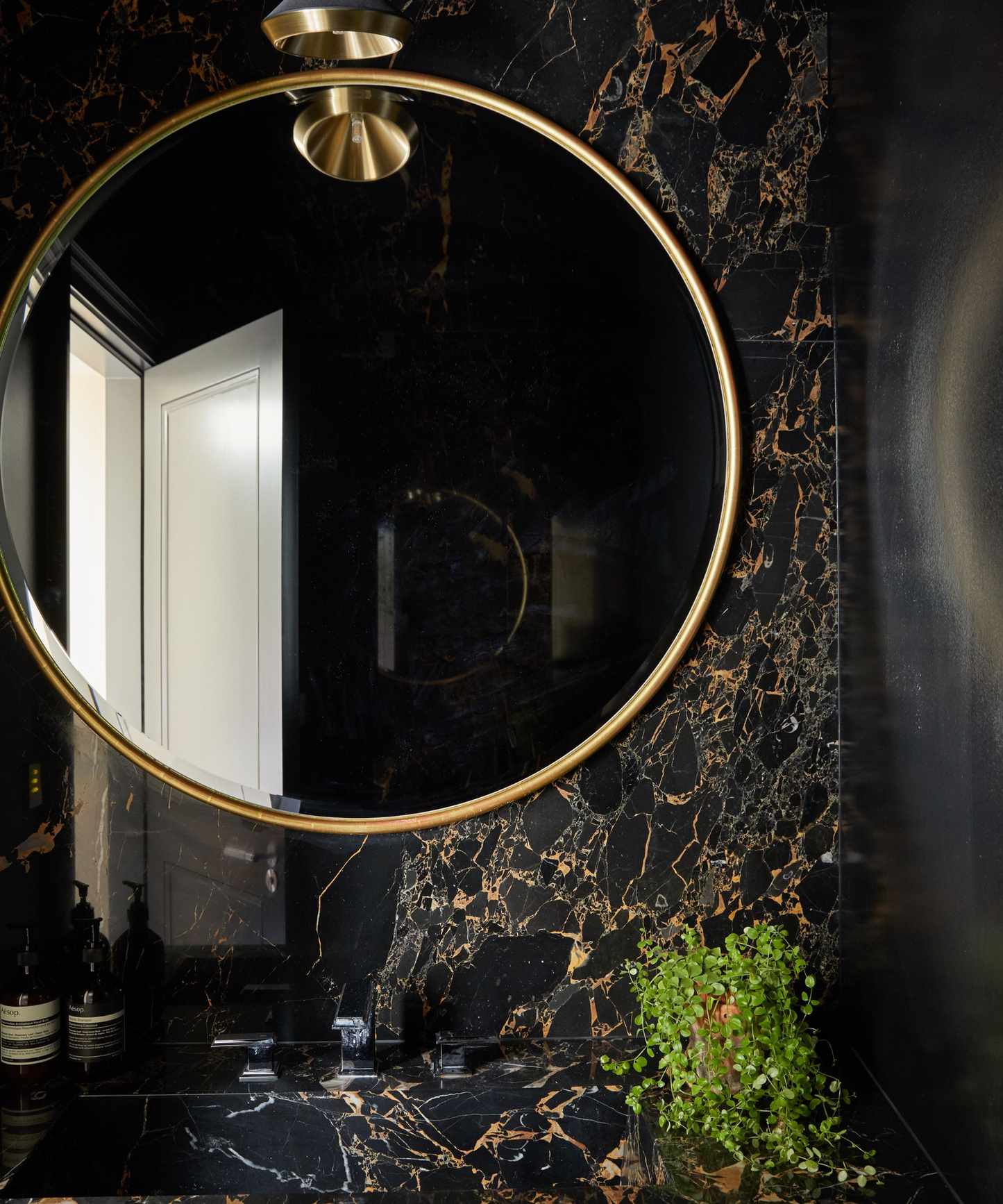 Dark powder room with large mirror