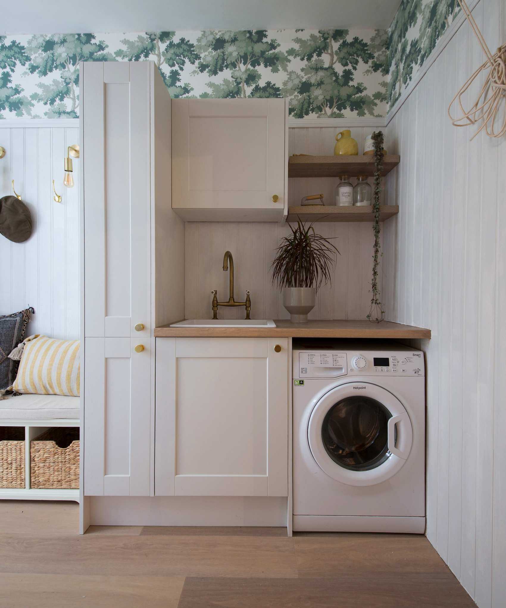 Industville Sleek Edison Wall Light - Brass image &ndash; a neutral laundry room with green and white wallpaper, and an entryway bench to the left