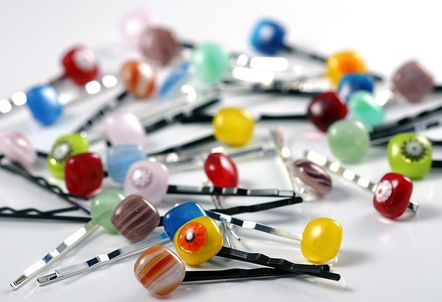 In this image, two handmade bobby pins are displayed, showcasing their sleek metal design, which has been a popular hair grip for women since their invention. The history of bobby pins dates back to the early 20th century, when they were originally sold as clips to hold bobbed hair styles, influencing fashion trends over the years.