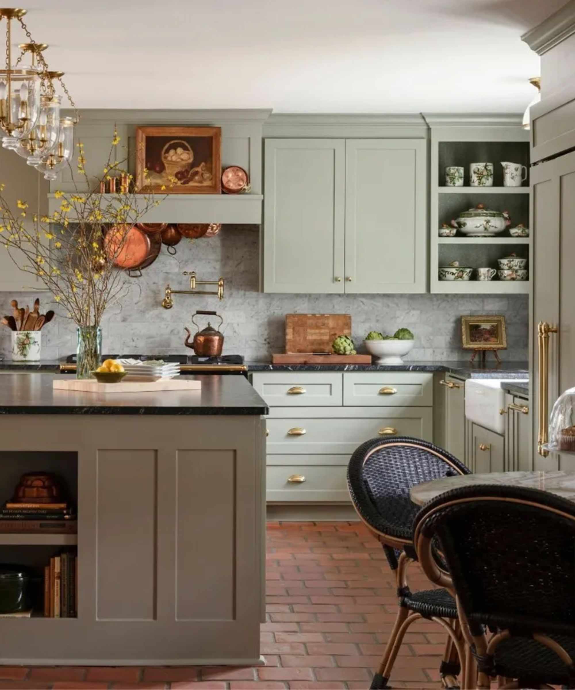 Cozy cottage kitchen with pale green kitchen cabientry and terracotta floor