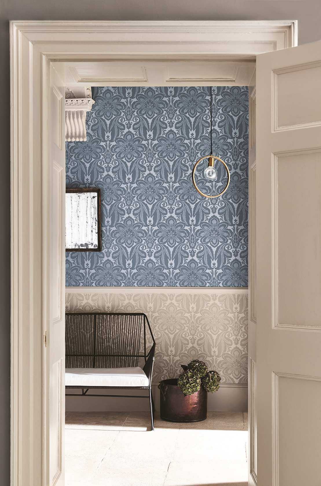 Patterned wallpaper above and below dado in hall with bench and plant