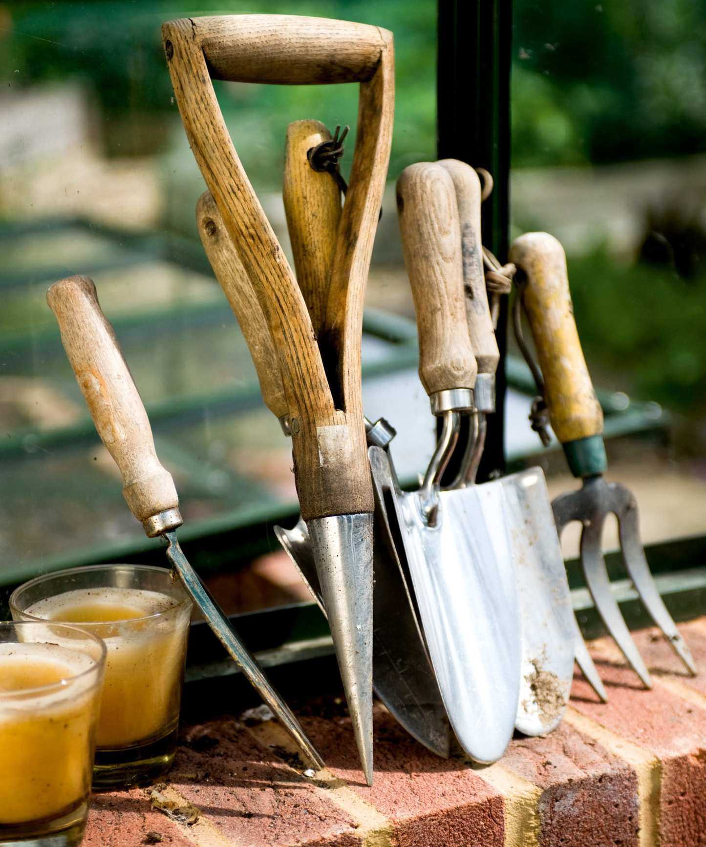 Gardentools stood on end on a brick wall