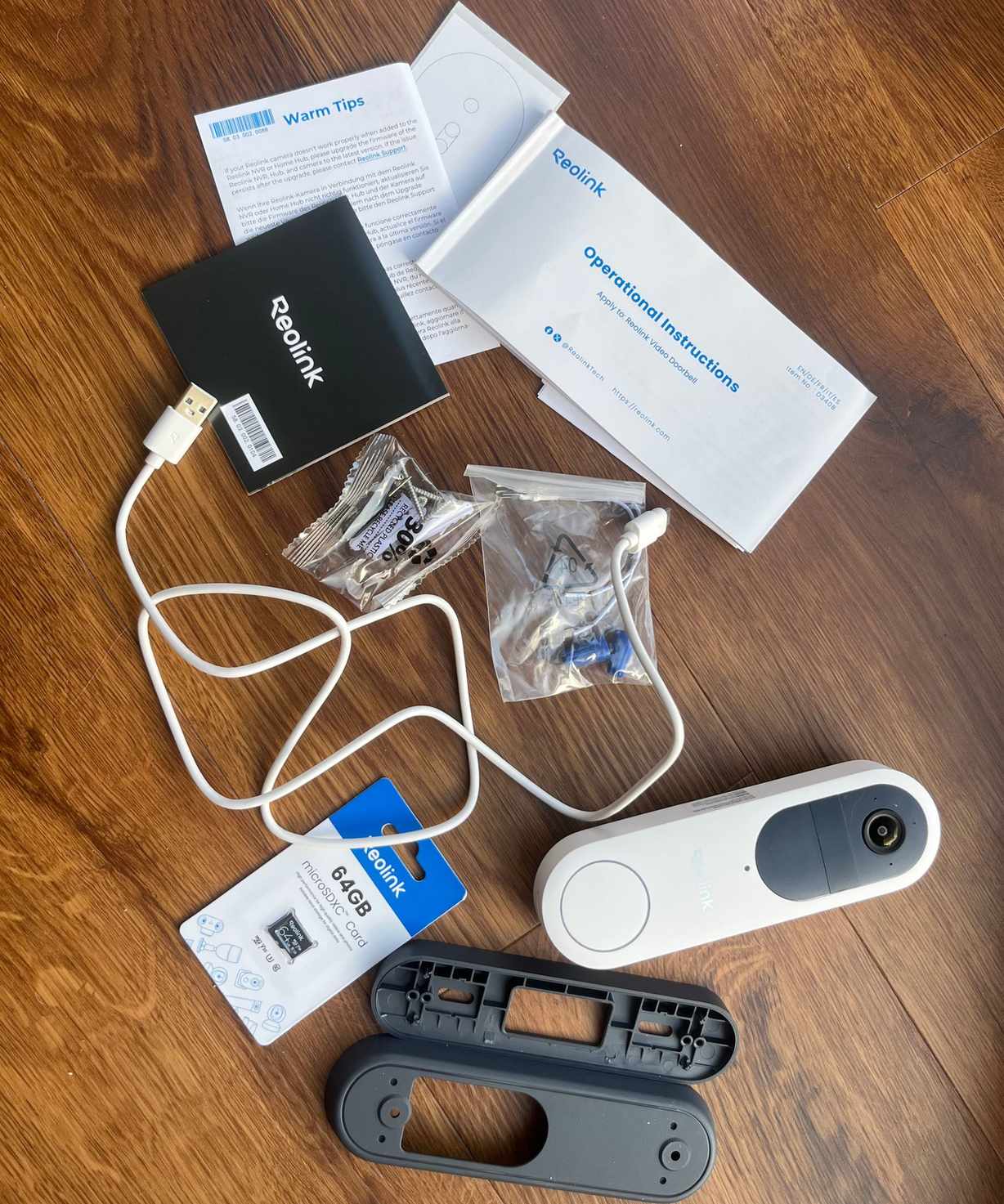 Every part included with the Reolink video doorbell on wooden surface.