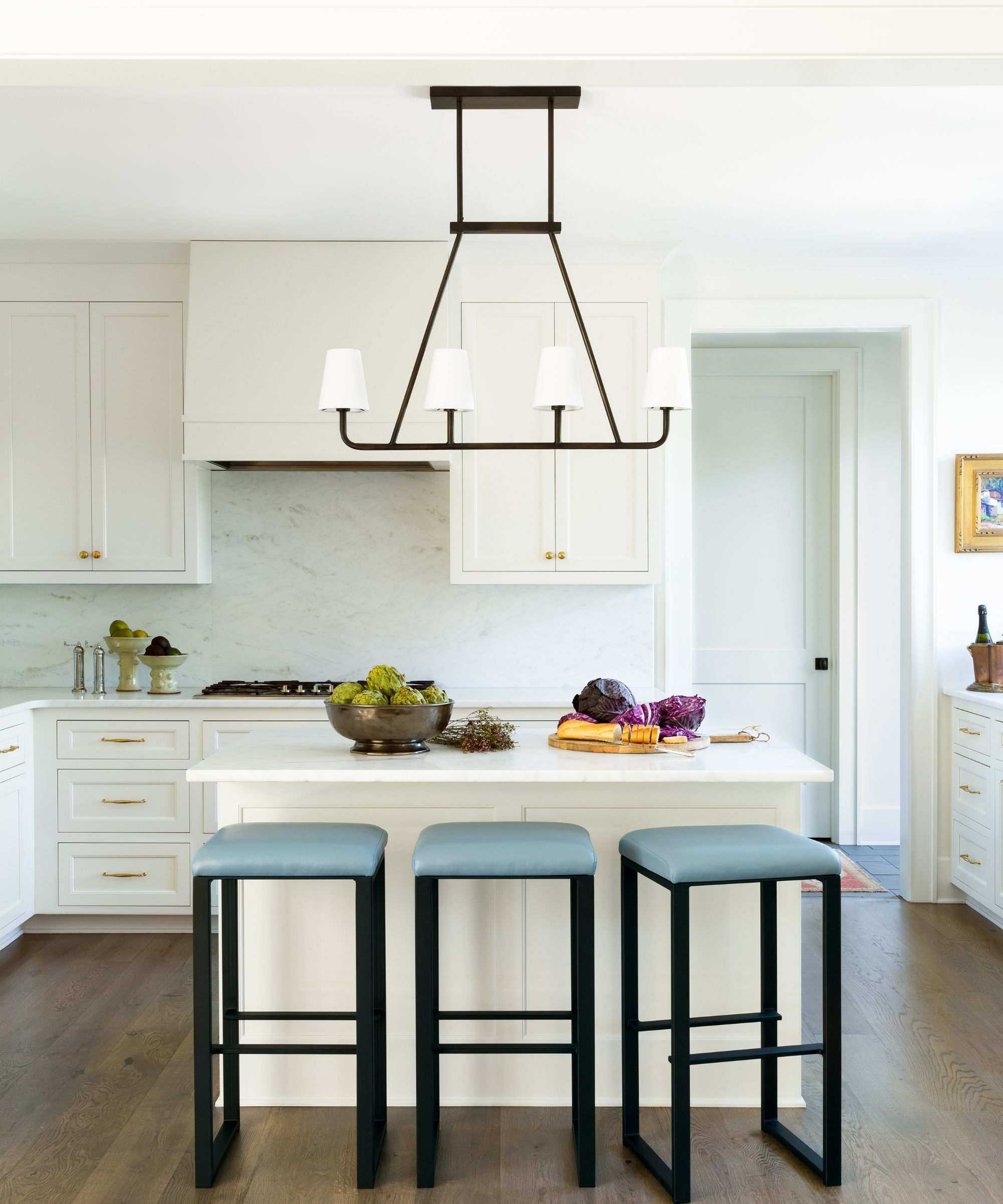 A white kitchen with blue bar stools