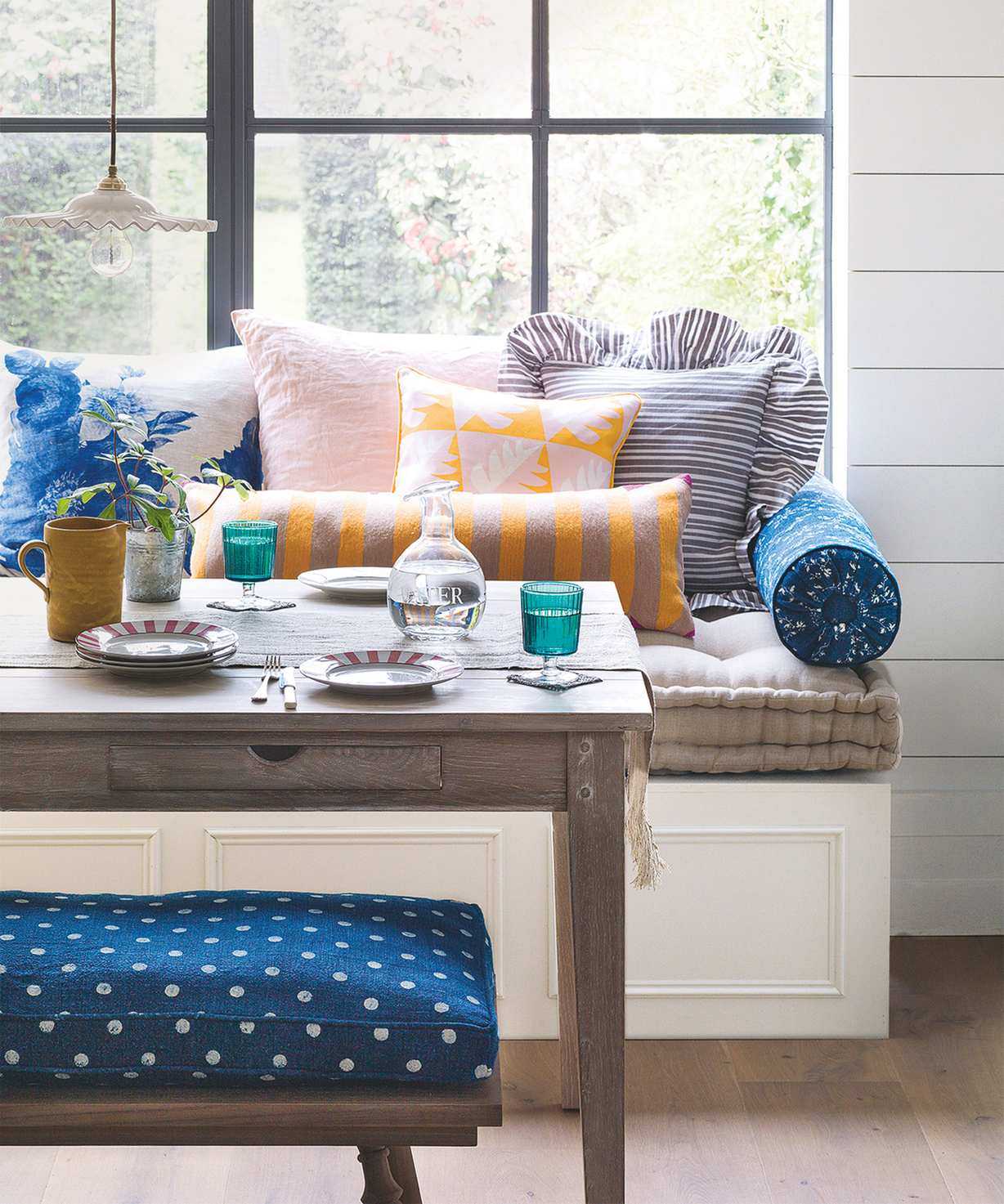 Dining room with window seat and colored glassware